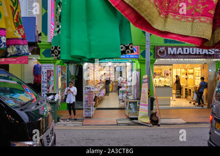 Boutiques dans la rue Dunlop, Little India, Singapour, vu de l'autre côté de la route avec des saris colorés encadrant le haut de la photo Banque D'Images