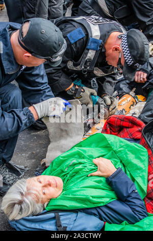 Londres, Royaume-Uni. 7Th Oct 2019. Commencer la police pour séparer les manifestants bloquant Whitehall - Rébellion Extinction démarrer l'action Octobre qui va bloquer les routes dans le centre de Londres jusqu'à deux semaines. Ils sont une nouvelle fois en lumière l'urgence climatique, avec le temps presse pour sauver la planète d'une catastrophe climatique. Cela fait partie de l'ER et d'autres manifestations pour exiger des mesures par le gouvernement britannique sur la 'crise climatique'. L'action fait partie d'une protestation coordonnée. Crédit : Guy Bell/Alamy Live News Banque D'Images
