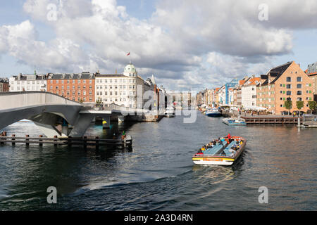 Copenhague, Danemark : Inderhavnsbroen pont piétons et les cyclistes. Un bateau de tourisme avec un guide qui donne un commentaire se transforme en Nyhavn. Banque D'Images