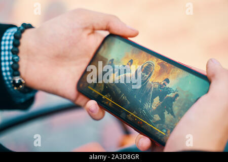 Bichkek, Kirghizistan - le 10 octobre 2019 : Chargement de l'écran. Jeu en ligne homme jouant dans call of duty mobile sur iphone 11 Banque D'Images