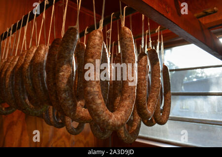 Petit-déjeuner traditionnel bio composé de saucisses accrochées dans une maison de fumée. Rassemblement familial pour la conservation des aliments, la viande de porc et le gibier d'un chasseur local Banque D'Images