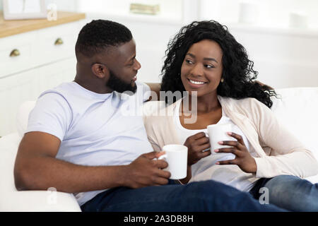 African American couple drinking coffee, détente à la maison ensemble. Banque D'Images