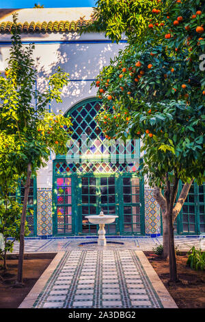 Petite fontaine blanche parmi les orangers du jardin Majorelle, Marrakech, Maroc Banque D'Images