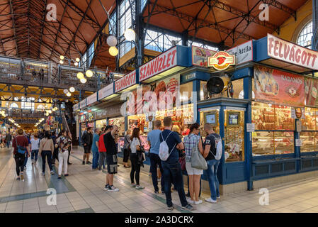 Les gens la queue à un boucher dans la Grande Halle de Budapest, Hongrie Banque D'Images