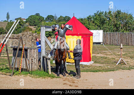 Chevalier médiéval en armure levé avec un levier pour monter son cheval avant d'jouter au Château de Tiffauges, Vendée, France Banque D'Images