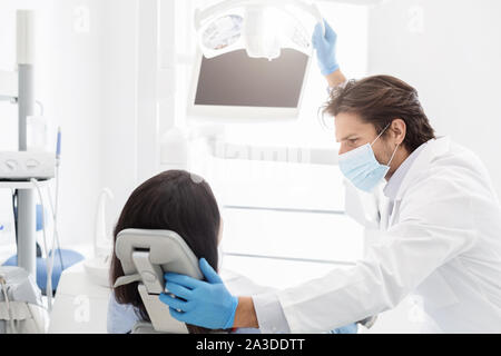 Dentiste attrayant réconfortant female patient sitting in chair Banque D'Images