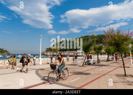 Femme à vélo le long de la piste cyclable à côté de la Playa de La Concha, San Sebastian, Pays Basque, Espagne Banque D'Images