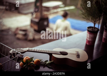 Guitare acoustique fixe sur la table avec des fruits cueillis frais au-dessus de cheminée Banque D'Images