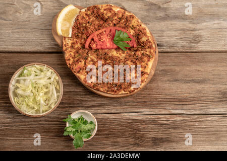 Pizza turque traditionnelle qui est faite de boeuf haché et l'oignon sur une table en bois avec accompagnements Banque D'Images