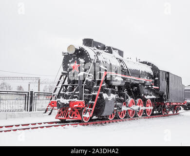 La vieille locomotive noire est garée dans la neige Banque D'Images