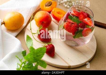 Punch aux fraises cocktail fait maison , et abricots frais loquat sur arrière-plan. Concept des boissons rafraîchissantes. Banque D'Images