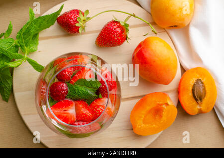 Punch aux fraises cocktail fait maison , et abricots frais loquat sur arrière-plan. Concept des boissons rafraîchissantes. Banque D'Images