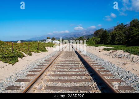 Voie ferrée à travers les dunes de sable couvert de glace verte plante le long de la côte de Californie route de trains de voyageurs à Santa Barbara Banque D'Images