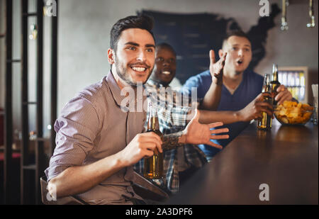 Les amateurs de football regarder match dans le sport bar, boire de la bière Banque D'Images
