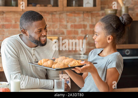 Adorable girl holding tray with des croissants frais Banque D'Images