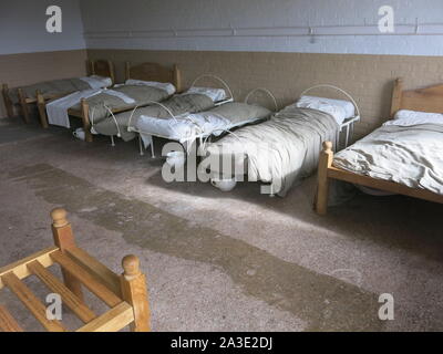 Re-imagining intérieur de la chambre à coucher Lits bébés pour les hommes ou femmes de l'un des dortoirs de cet établissement victorien Workhouse. Banque D'Images