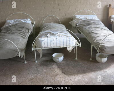 Re-imagining intérieur de la chambre à coucher Lits bébés pour les hommes ou femmes de l'un des dortoirs de cet établissement victorien Workhouse. Banque D'Images