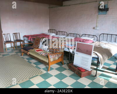 Re-imagining intérieur de la chambre à coucher Lits bébés pour les hommes ou femmes de l'un des dortoirs de cet établissement victorien Workhouse. Banque D'Images