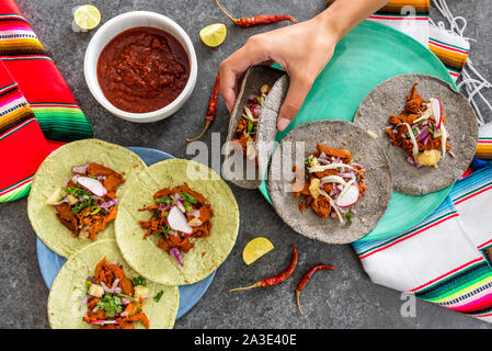 Vue de dessus d'une main tenant une femelle taco avec viande et légumes Banque D'Images