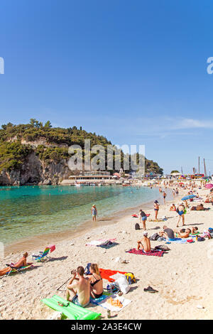 Les vacanciers et les touristes profitant du soleil sur la plage de sable de la station balnéaire de Paleokastrita grec sur l'île de Corfou en Grèce Banque D'Images