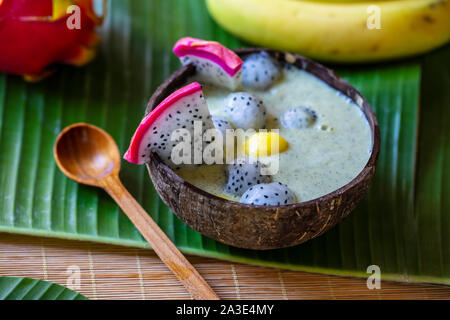 Smoothie aux fruits du dragon dans la noix de coco bowl Banque D'Images