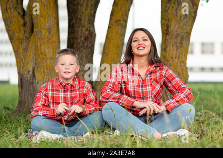 Maman fils enseigne le yoga sur la pelouse. Banque D'Images