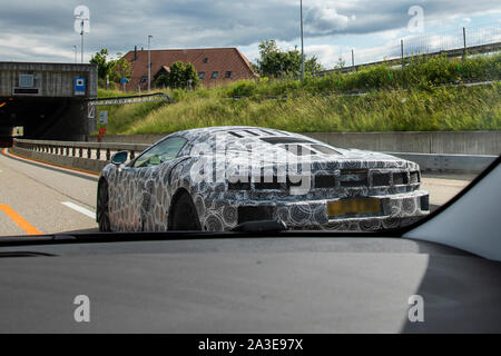 Un vehiche McLaren GT test prototype photographié faisant essais routiers en Suisse. L'extrémité arrière et l'admission d'air fortement avec les deux bandes camo camouflé et l'utilisation des panneaux. Les feux arrière sont cachés sous panneau mesh. Le nouveau modèle a d'abord annoncé à l'Auto Salon de Genève 2019, mais les détails au sujet de la voiture a été d'abord publié en mai la même année. Ces images ont été prises en juin 2019 et diffère de l'heure in ayant sauté sur le panneaux supplémentaires et le côté arrière, ainsi que des feux arrière camouflées. Le contour de la queue sont visibles à travers la bande. Banque D'Images