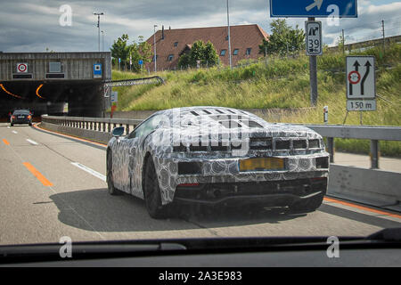 Un vehiche McLaren GT test prototype photographié faisant essais routiers en Suisse. L'extrémité arrière et l'admission d'air fortement avec les deux bandes camo camouflé et l'utilisation des panneaux. Les feux arrière sont cachés sous panneau mesh. Le nouveau modèle a d'abord annoncé à l'Auto Salon de Genève 2019, mais les détails au sujet de la voiture a été d'abord publié en mai la même année. Ces images ont été prises en juin 2019 et diffère de l'heure in ayant sauté sur le panneaux supplémentaires et le côté arrière, ainsi que des feux arrière camouflées. Le contour de la queue sont visibles à travers la bande. Banque D'Images