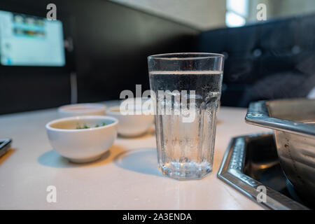 Verre de l'eau assis dans restaurant avec divers bols et hot pot Banque D'Images