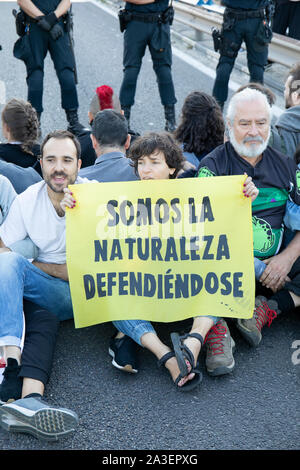 Un groupe de manifestants tiennent une bannière qui dit que nous sommes la nature en défense pendant la manifestation.Villes du monde comme Londres, Berlin, New York, Buenos Aires, Paris a commencé la deuxième semaine internationale des militants alors que la rébellion effectuer à différentes actions de protestation pacifique et de désobéissance civile en vertu de l'obligation éthique de responsabilité politique pour récupérer une action dans le but d'atténuer les graves conséquences du changement climatique et l'impact écologique. À Madrid il y a deux actions parallèles, l'un en "Paseo de la Castellana", où une route principale a été bloquée pour une chaîne humaine et il y avait tellement Banque D'Images