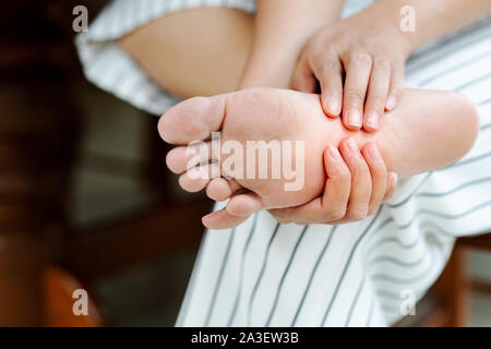 Femme en massant son douloureux pieds nus, les soins de santé et concept médical Banque D'Images