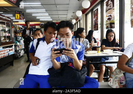 ANTIPOLO CITY, PHILIPPINES - le 3 octobre 2019 : les adolescents reste à enregistrer et jouer jeu vidéo sur smartphone Banque D'Images