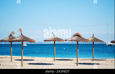 Paysage idyllique, concept de vacances d'été, parasols de paille dans une rangée sur la côte de la mer Méditerranée, l'île de Majorque, Baléares, Espagne Banque D'Images