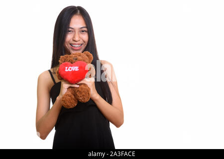 Les jeunes professionnels Asian teenage girl smiling while holding teddy bear Banque D'Images