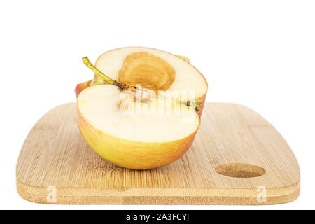 La moitié des pourris jonagold red apple avec plaque de bambou isolé sur fond blanc Banque D'Images