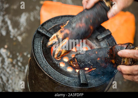 Jarrets de jambon en petit grillage fire pit dans marché du matin à Hanoi, Vietnam Banque D'Images