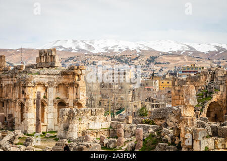 Ruines du grand temple de Jupiter de la Cour, avec des maisons libanaises dans l'arrière-plan, vallée de la Bekaa, Baalbeck, au Liban Banque D'Images