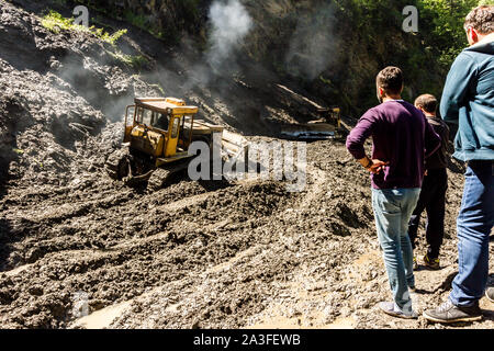 Omalo, Géorgie - 13 juin 2016 : les travailleurs avec le tracteur déposer le glissement de terrain sur la route de montagne, Tusheti Banque D'Images