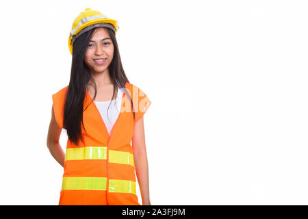 Studio shot of young happy Asian woman construction worker smili Banque D'Images