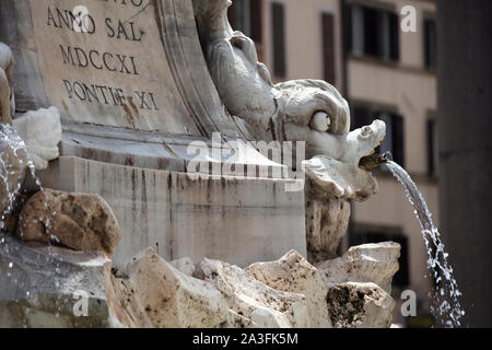 Un bec d'eau pour dauphin sur la Fontana del Pantheon à Rome. Dans l'arrière-plan peut être vu quelques bâtiments romains traditionnels entourant la piazza. Banque D'Images