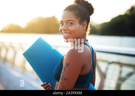 Dark-eyed woman showing dents sourire en allant à la séance d'entraînement Banque D'Images