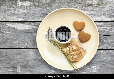 Petit-déjeuner scandinave à la mer : café, biscuits en forme de cœur, de lavande et d'un shell sur une vieille table en bois patiné, profiter de moments simples de votre vie Banque D'Images