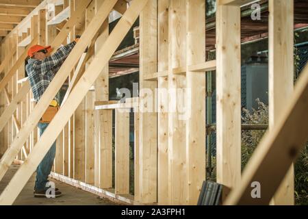 La construction des maisons de bois. Young Entrepreneur Carpenter bâtiment de finition en bois apparentes. Thème industriel. Banque D'Images