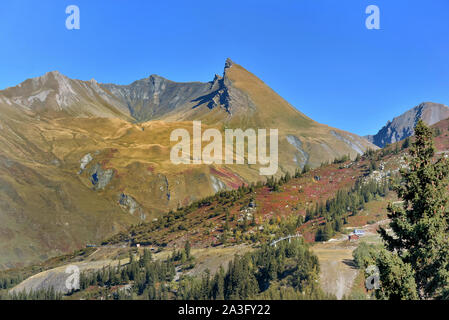 Vue sur la montagne des Alpes couvertes de couleurs jaune et rouge à l'automne sous ciel bleu Banque D'Images