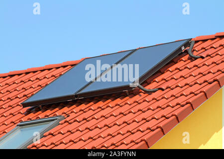 Des panneaux solaires sur le toit de tuiles rouges Banque D'Images