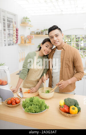 Smiling Young Asian couple la cuisson des aliments dans la cuisine Banque D'Images