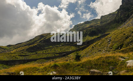 Panorama spectaculaire de la célèbre col Transfagarasan serpentant à travers les montagnes de Fagaras et fluffy clouds un jour d'été, Roumanie Banque D'Images