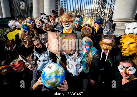 Leontien Friel Darrell (centre) de Tipperary, lit un discours appelant à un budget pour le changement climatique le jour de l'Irish budget, aux portes de bâtiments gouvernementaux à Dublin avec l'extinction des manifestants rébellion portant des masques d'animaux. Banque D'Images