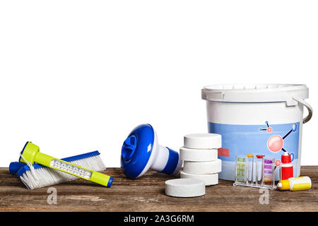 Excellent équipement avec des produits de nettoyage chimiques, outils, filtres, brosses et thermomètre pour l'entretien de la piscine sur un surf en bois Banque D'Images