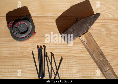 Des clous et marteau ruban de mesure sur table en bois Banque D'Images